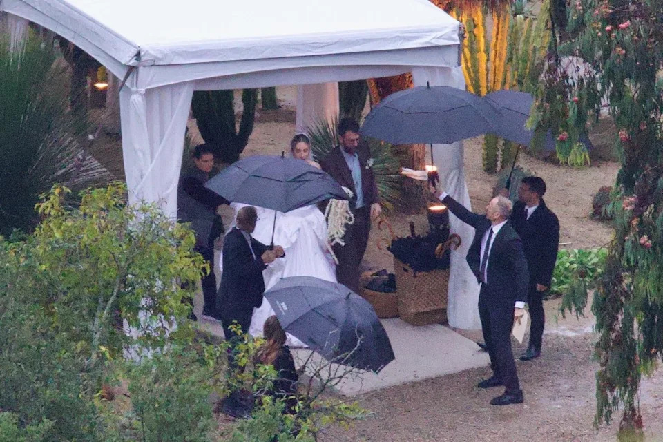 The couple escaped the rain under umbrellas. BACKGRID