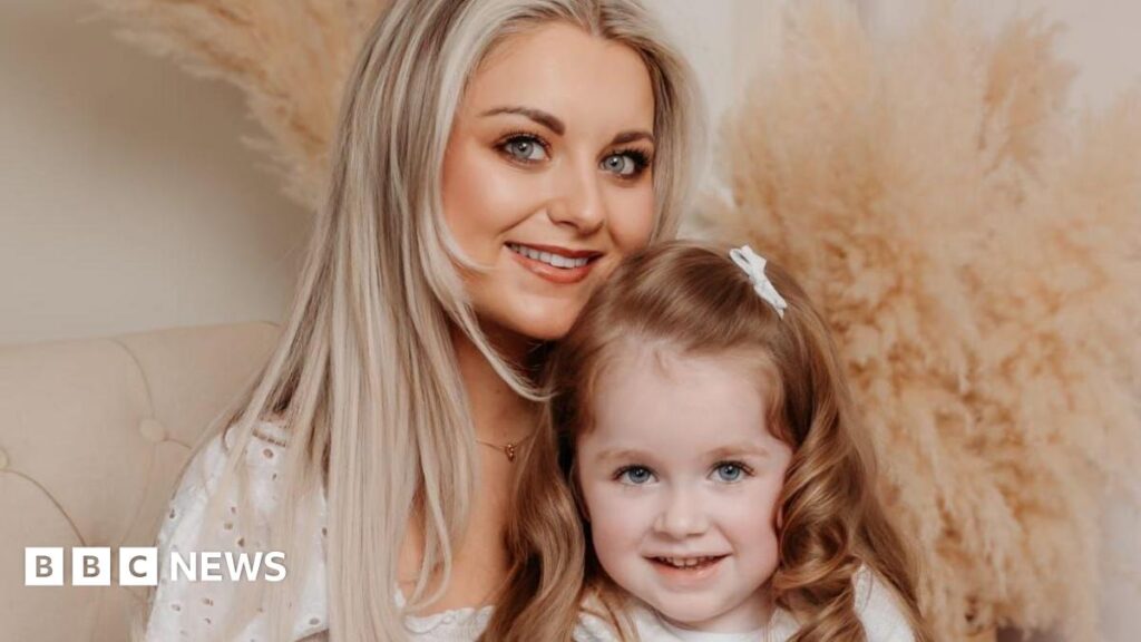 SMA: ‘I want to tell Jesy Nelson, there’s hope’, says Newry mum A couple, their five-year-old son and their baby daughter pose for a family portrait in front of a grey backdrop. The dad, on the left, has short brown hair and wears a white T-shirt. His son sits in front of him and has short brown hair and a matching T-shirt. The mum, on the right, has long blonde hair, partially plaited, and wears a white top and gold and purple wristbands. She is holding a baby girl who is wrapped in light green muslin and wears a green headband.