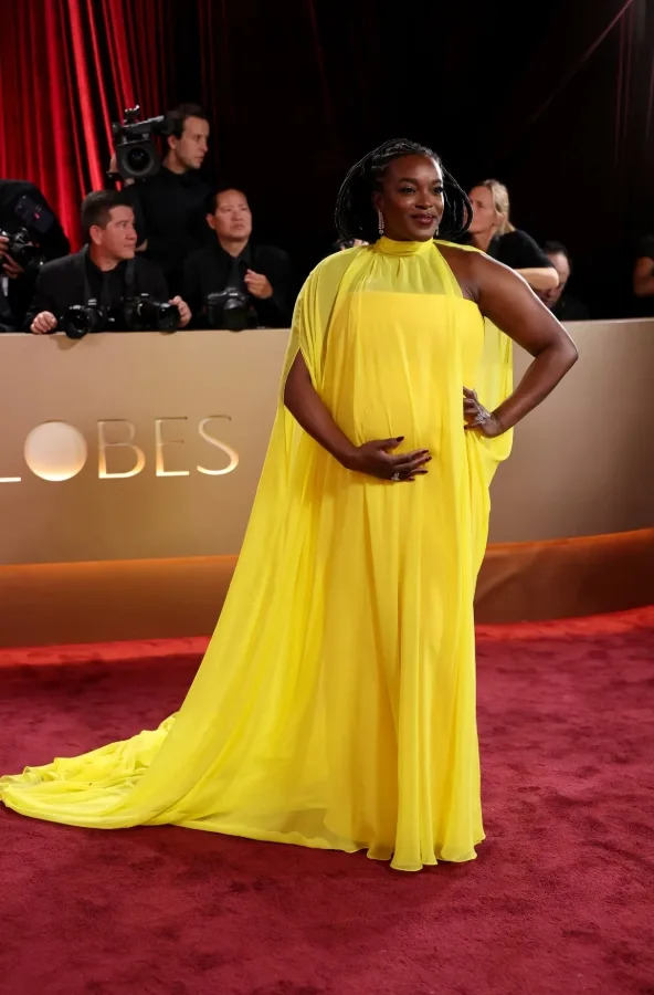 Wunmi Mosaku wearing a flowing yellow gown while showing her baby bump on the 2026 Golden Globes red carpet.
