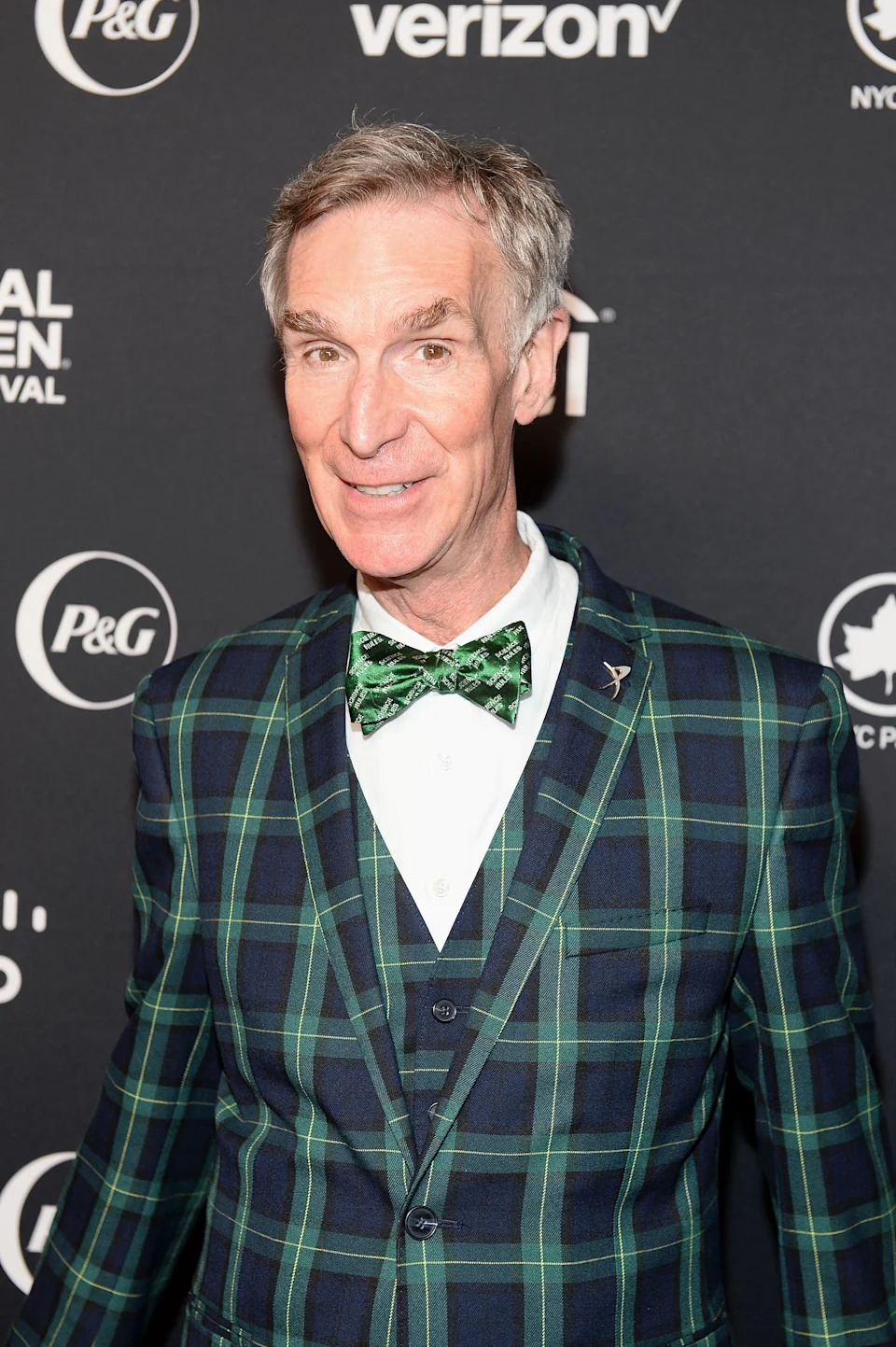 Person in a patterned plaid suit and bow tie attends a formal event