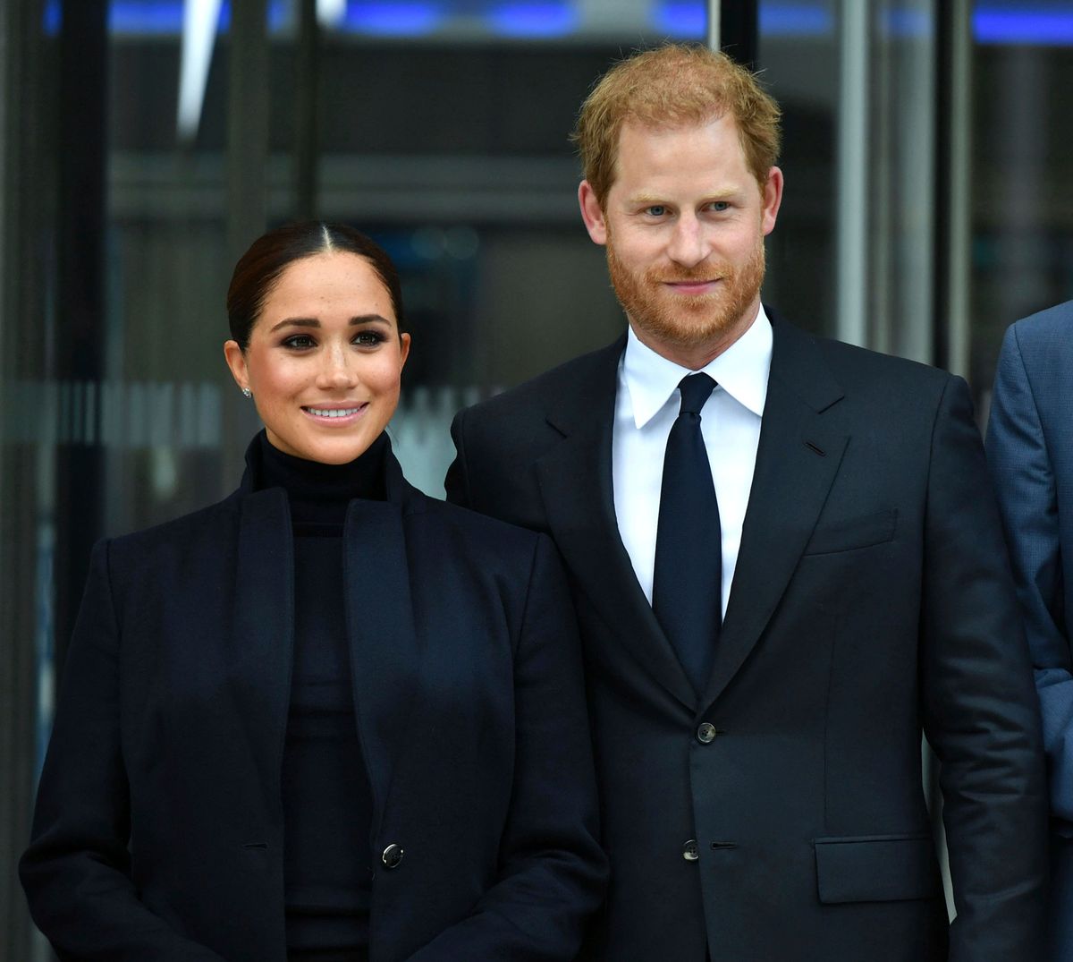 Prince Harry and Meghan Markle standing together wearing dark, formal clothes