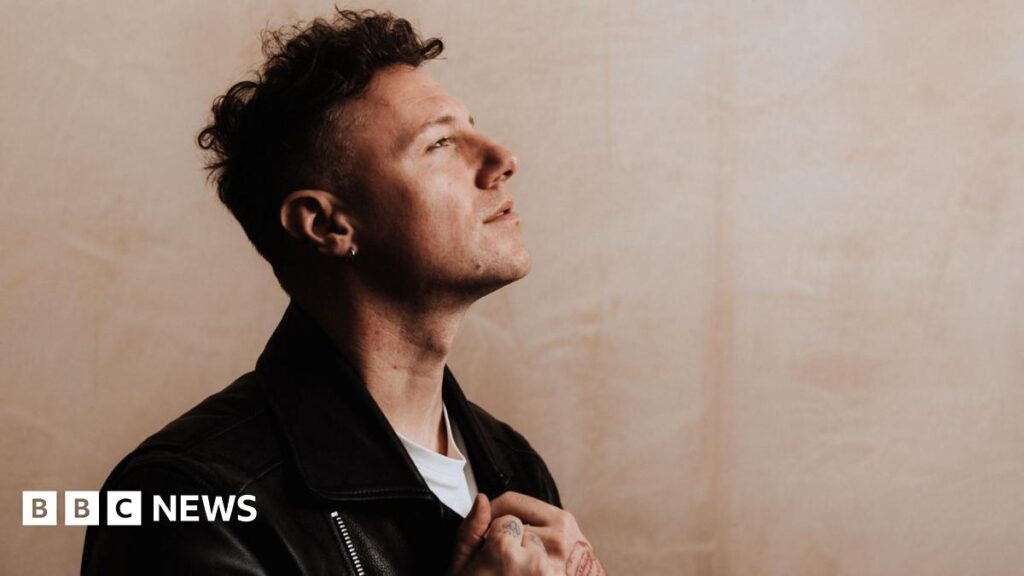 Singer Callum Beattie on making ‘milestone moments’ Callum Beattie has dark hair and is pictured in profile wearing a dark jacket over a white T-shirt. His head is titled upwards as he looks off to the distance.