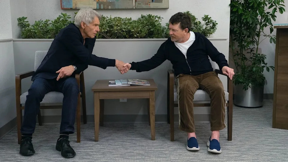  Michael J. Fox shaking hands with Harrison Ford while seated in doctor's waiting room in Shrinking. 