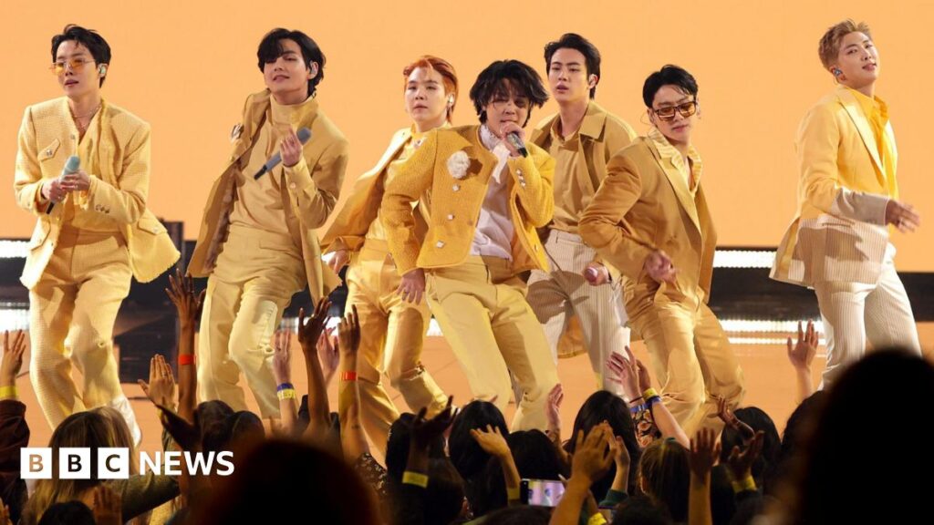 BTS on stage in matching yellow suits