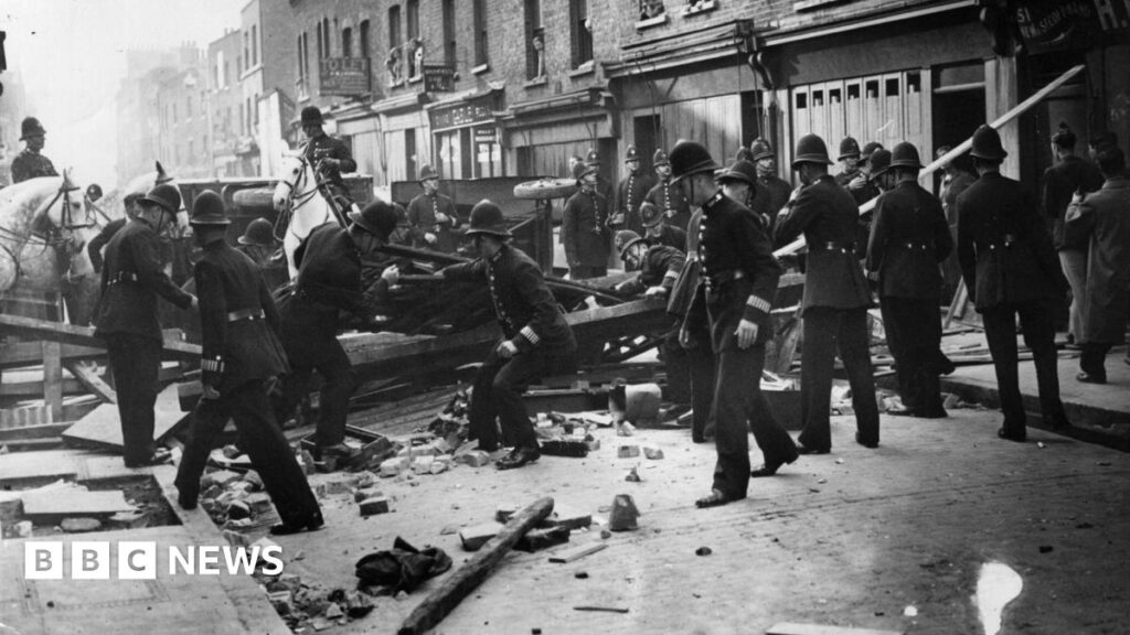 Black and white image of police fighting with anti-fascists protesters on Cable Street.