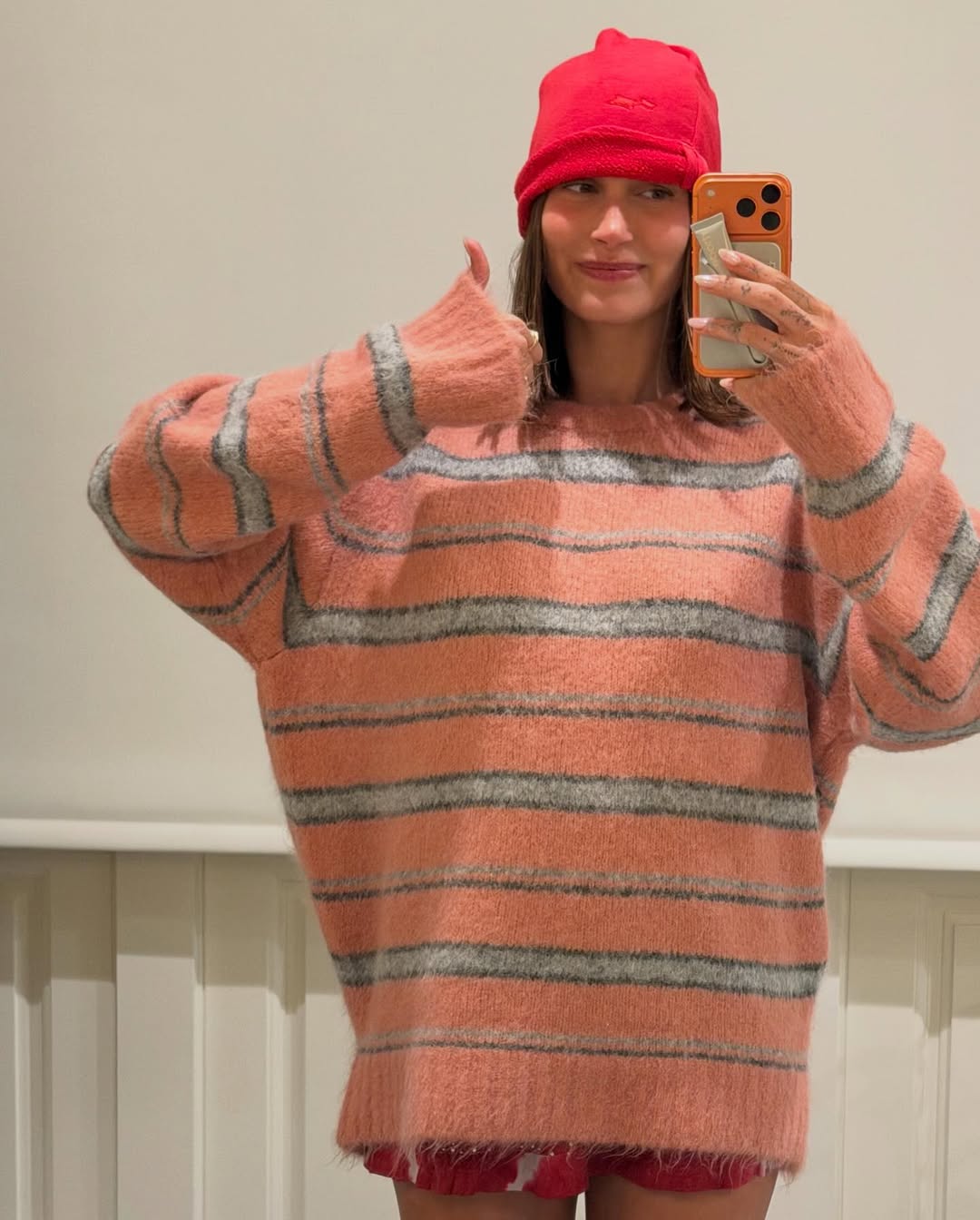 Hailey Bieber shares a new Instagram post wearing a vintage Roberto Cavalli swimsuit, an oversize striped sweater, and carrying a brand new Chanel 2026 tote bag