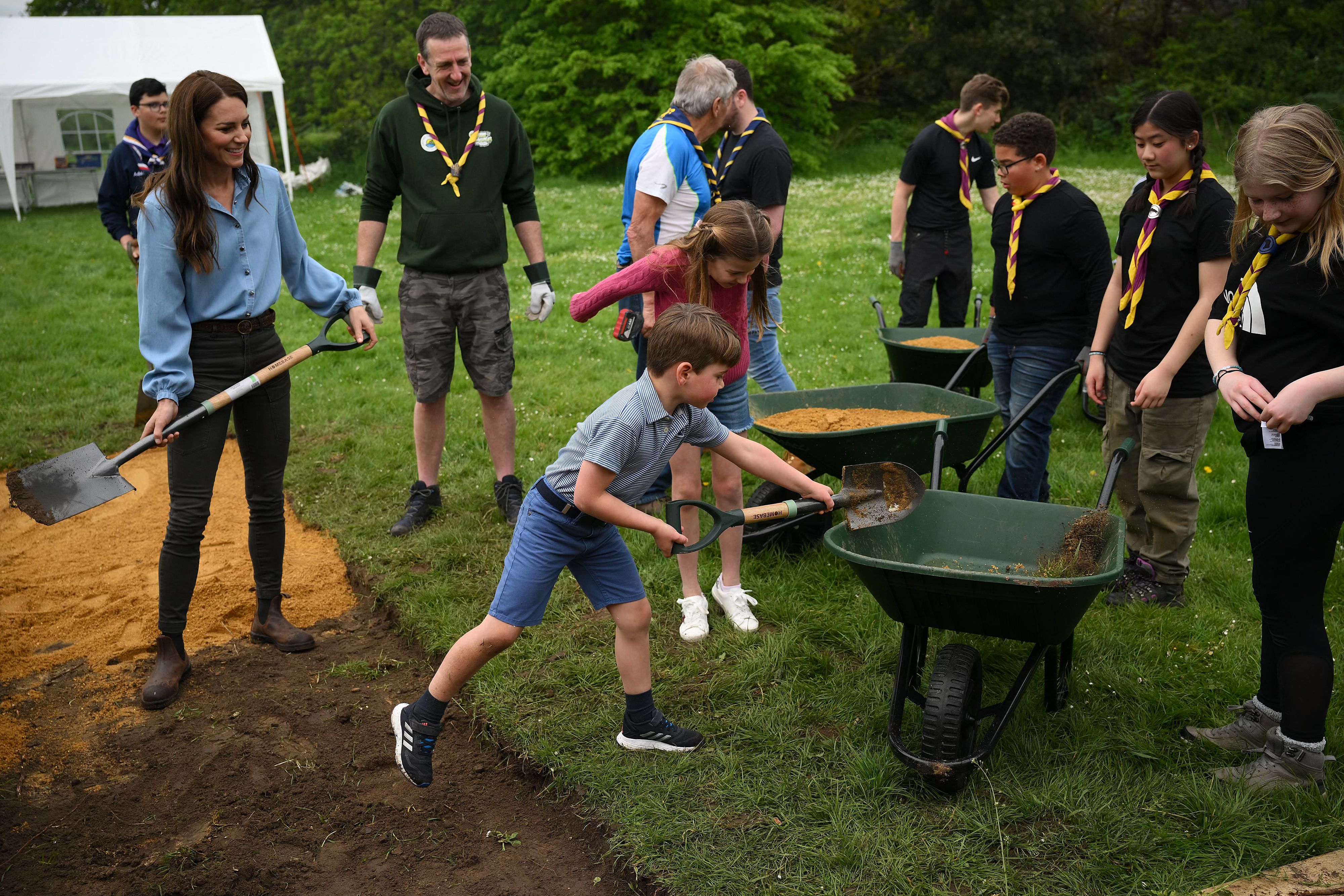 Princess Charlotte and Prince Louis shoveling dirt into a wheelbarrow