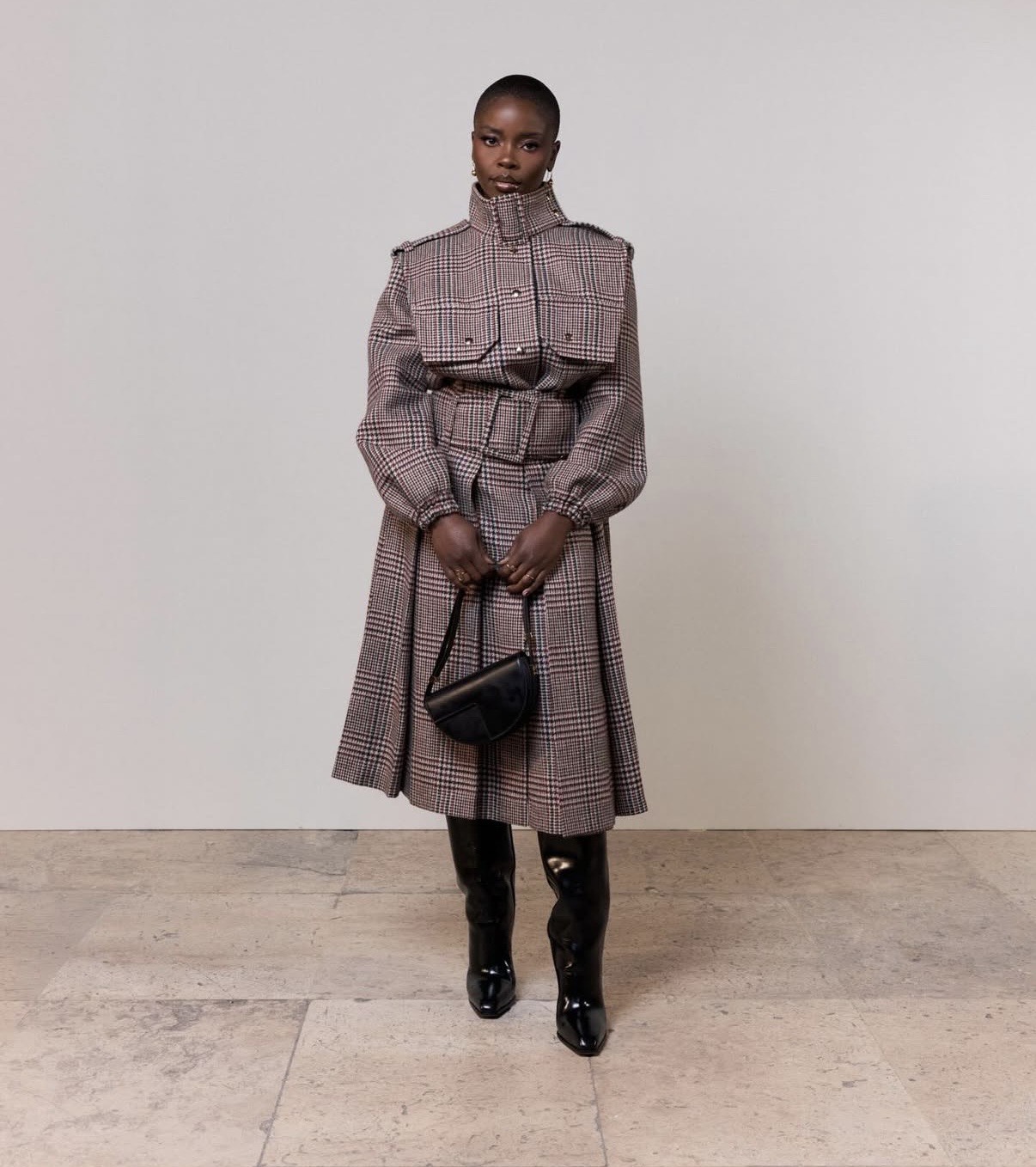 Joy Sunday in a belted plaid coat dress at Paris Fashion Week, blending tailored elegance with haute couture week outfit influence