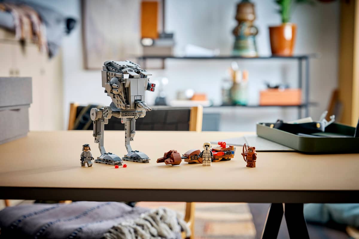 LEGO figures on a desk featuring an AT-ST, speeder bike and Ewok