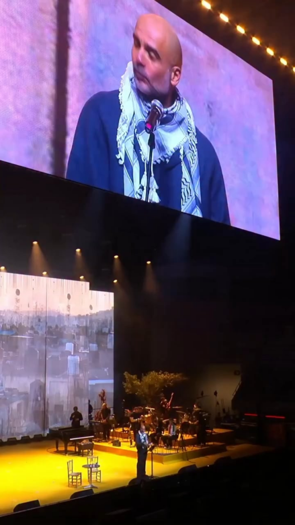 Manchester City manager Pep Guardiola speaks for the children of Gaza during the Act x Palestine charity event, wearing a Palestinian keffiyeh, in Barcelona.