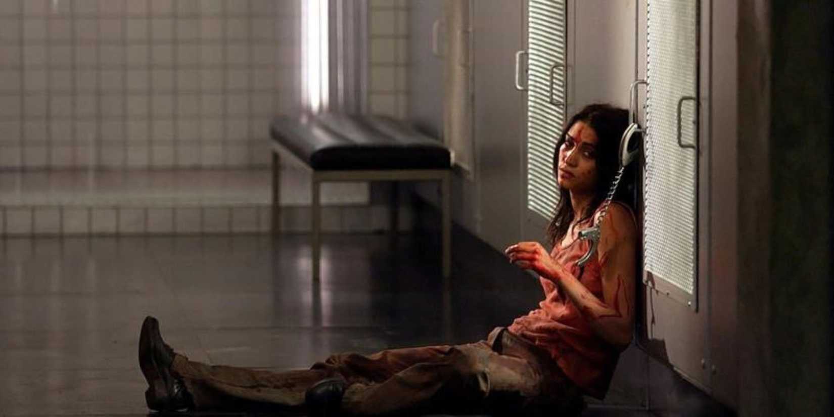 A distressed woman covered in blood while chained to a handle in Martyrs.