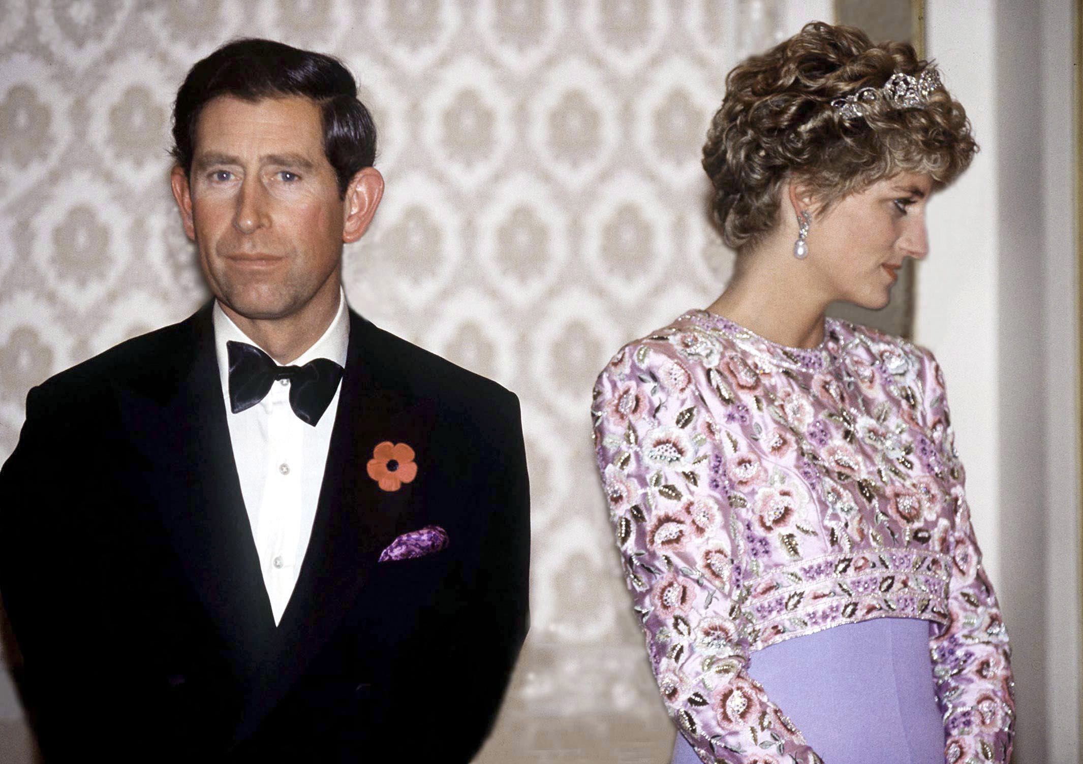Prince Charles and Princess Diana looking away from each other at a banquet