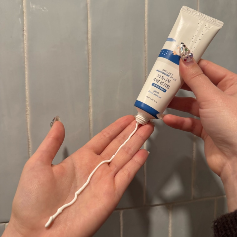 Woman dispensing sunscreen on palm