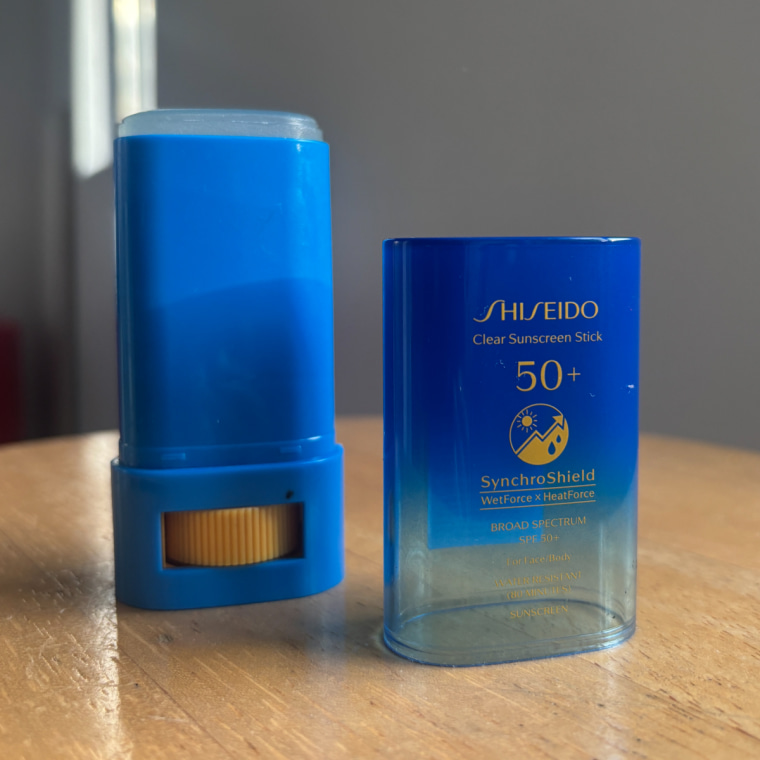 Stick sunscreen on wooden table.