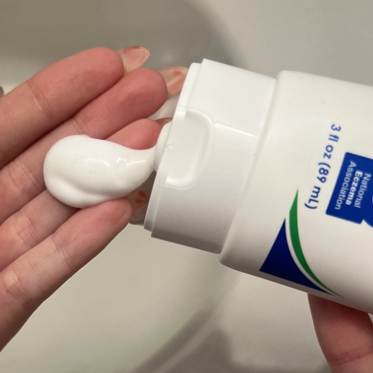Woman dispensing cream on her hands.