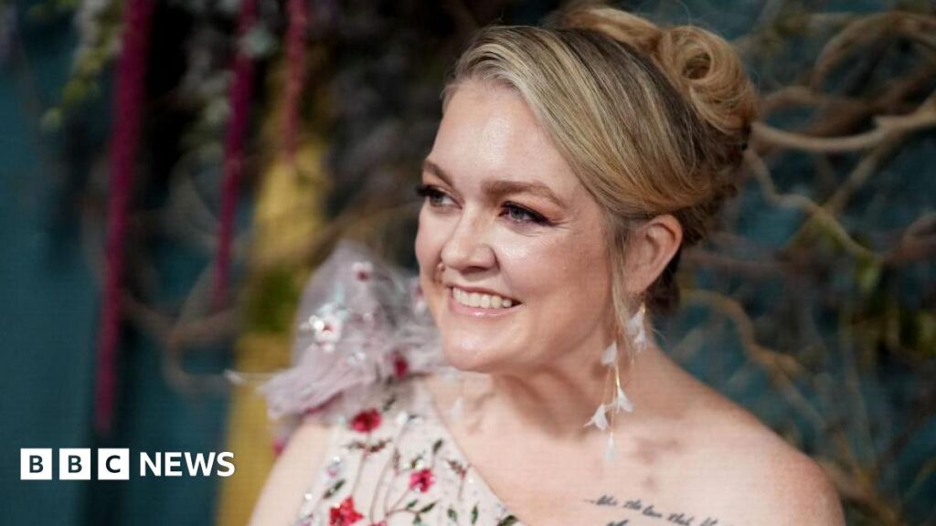 Prime Minister Mark Carney, wearing a black suit jacket, and a white button-up shirt leans his chin on his hands. He has short grey and black hair and is looking away from the camera.