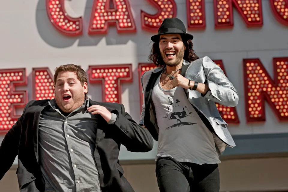 Jonah Hill and Russell Brand running out of a casino enthusiastically