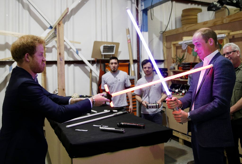 Prince Harry and Prince William try out light sabres during a tour of the Star Wars sets at Pinewood studios on April 19, 2016  in Iver Heath, England. 