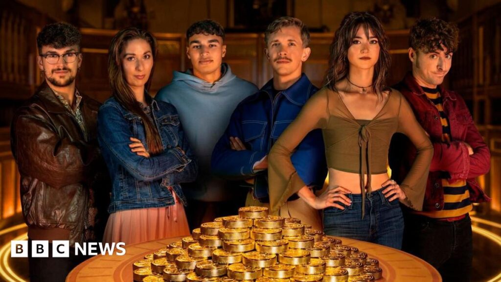 Stephen, Rachel and Claudia Winkleman holding up glasses of champagne and smiling behind a table with a pile of gold coins
