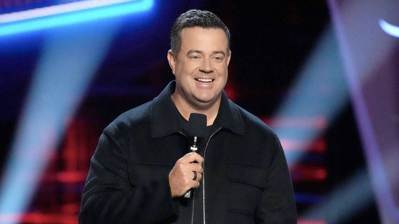 Carson Daly hosting The Voice and holding a microphone in 2024