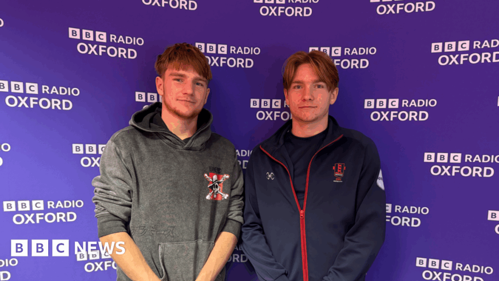 Charlbury boxing twins open up about fostering journey Identical twins Chris and Johnny standing in front of a purple BBC branded background.