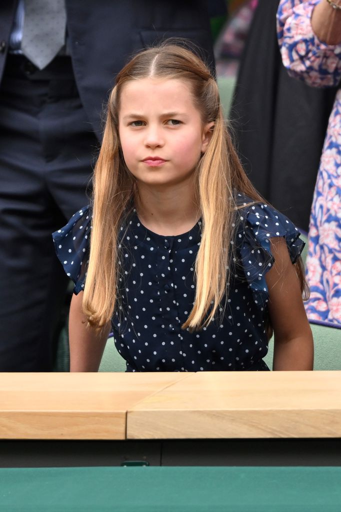 Princess Charlotte frowning in navy polka dot dress