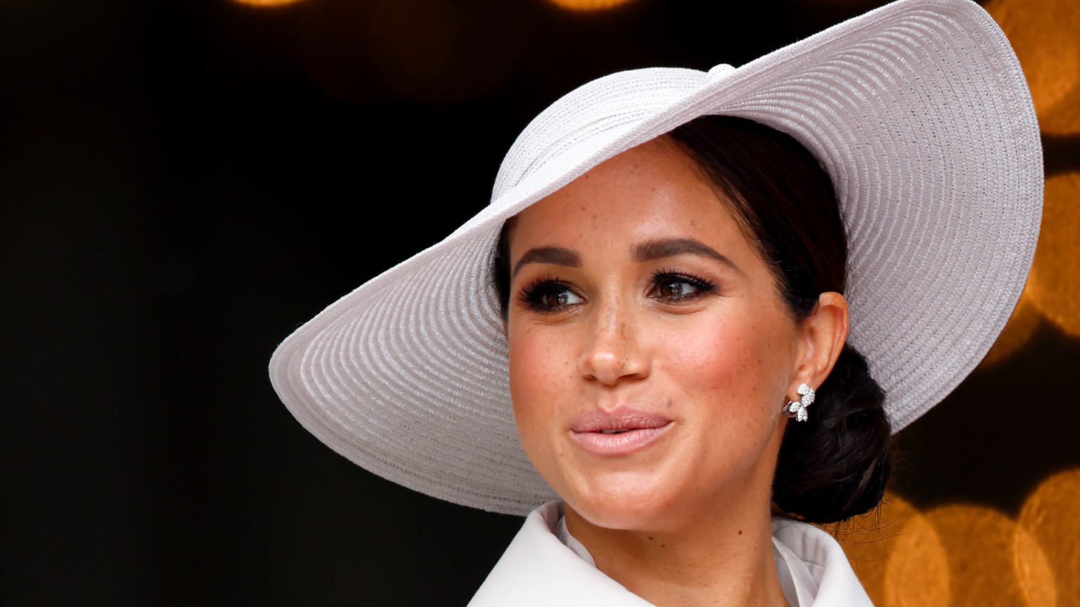 Meghan Markle wearing a white hat and coat