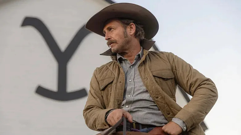 Young John Dutton in front of the Yellowstone logo on Yellowstone (2018-2024)