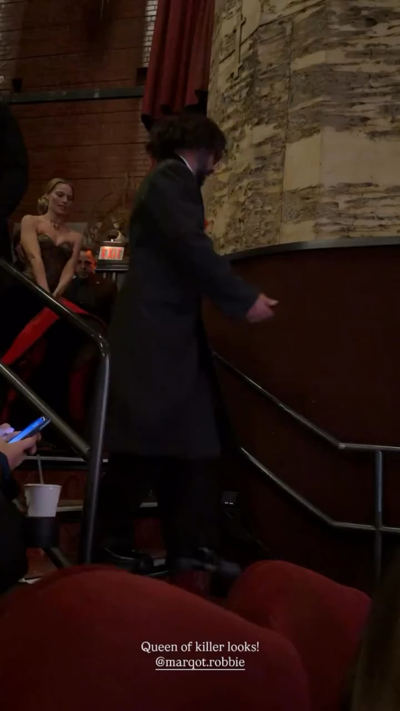 Margot Robbie struggling to walk down the stairs in her Schiaparelli gown at the LA premiere of Wuthering Heights