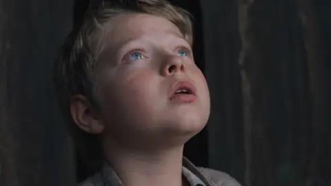 Focus Features The young Hamnet looking up with a worried expression