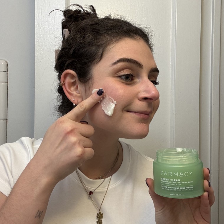 Woman applying cleansing balm to her face
