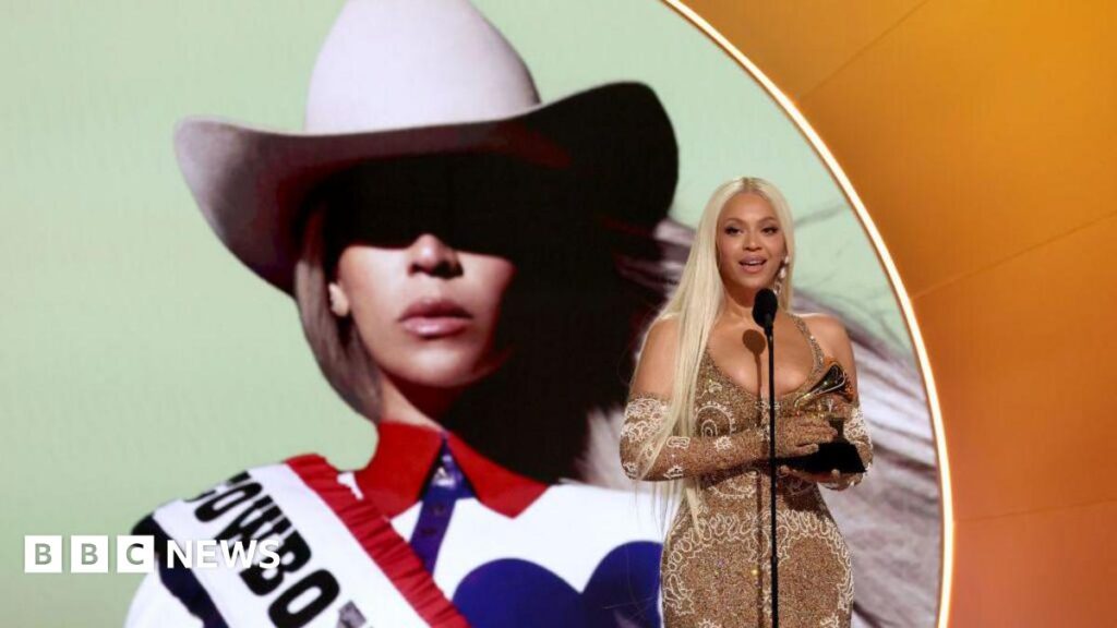 Beyoncé wears a golden gown and accepts the Best Country Album award for "Cowboy Carter" onstage during the 67th  Grammy Awards at Crypto.com Arena on 2 February 2025 in Los Angeles, California. An image of her album cover is projected behind her