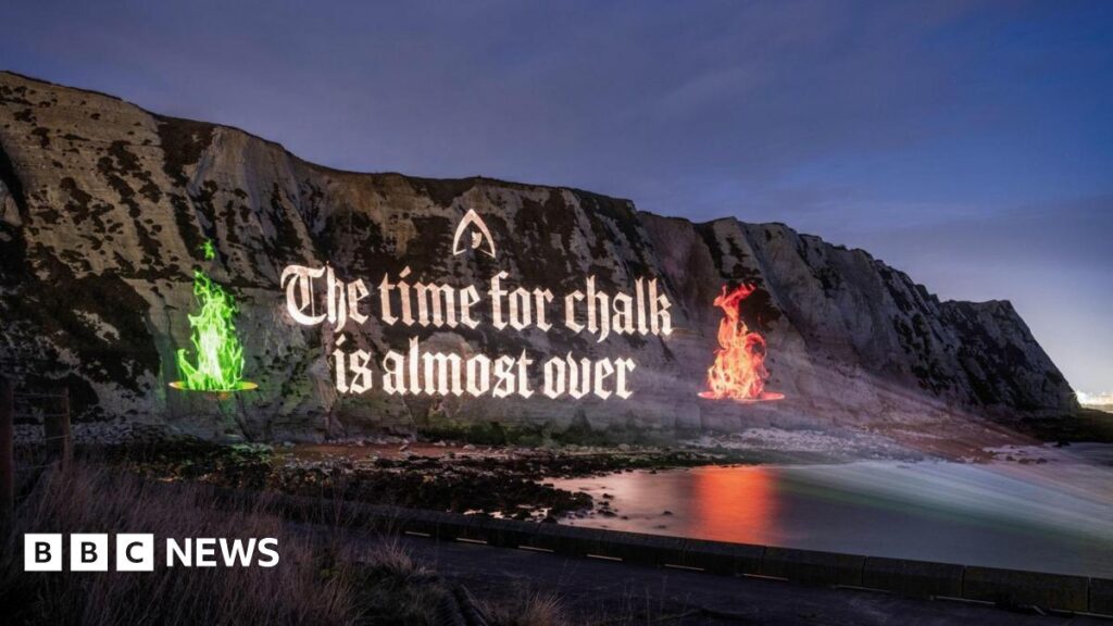 The image shows a projection on the White Cliffs of Dover with the phrase "THE TIME FOR CHALK IS ALMOST OVER" ahead of The Traitors final airing this Friday on BBC One and iPlayer.