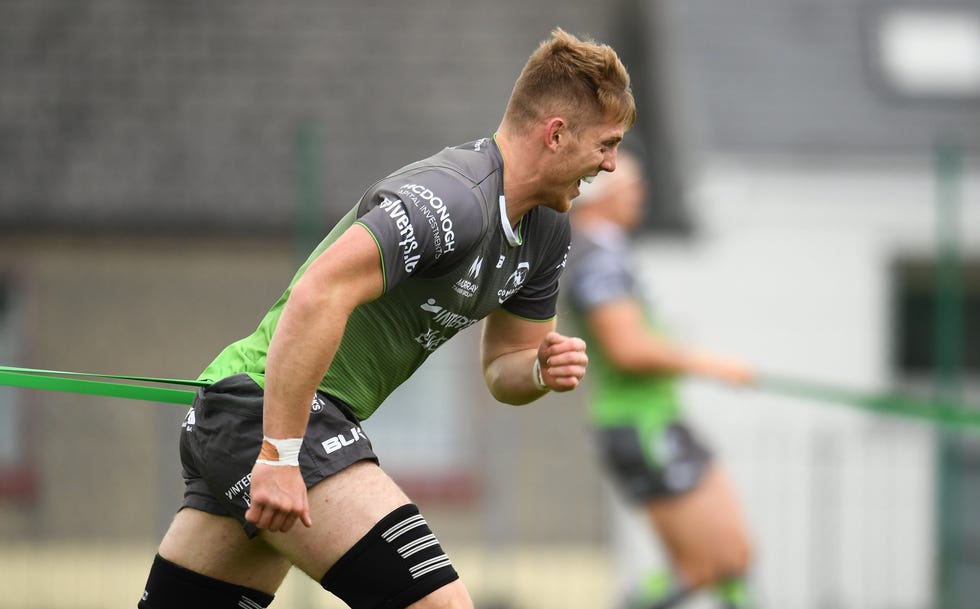 rugby player running as he is held back by a resistance band