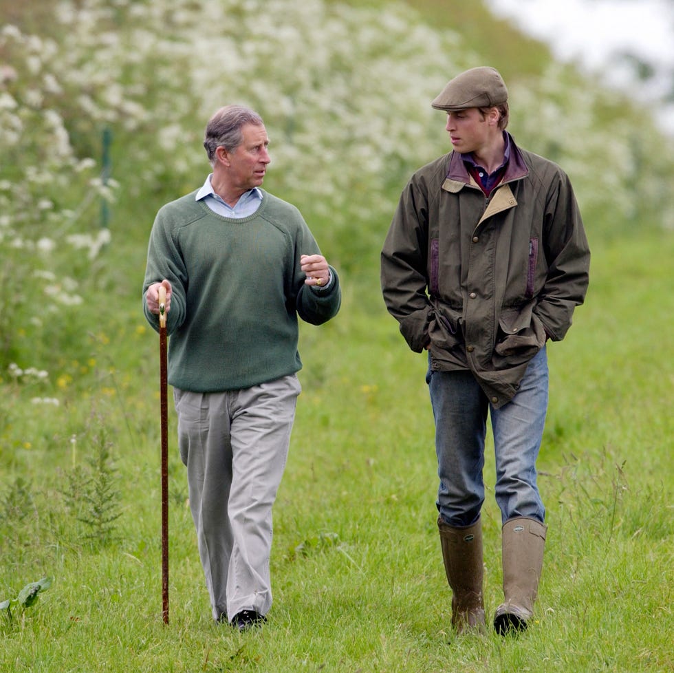 Prince William And Prince Charles prince william, in countryman outfit of tweed cap and waxed jacket and with his hands in his pockets, visits duchy home farm with prince charles who is holding a shepherds crook walking stick