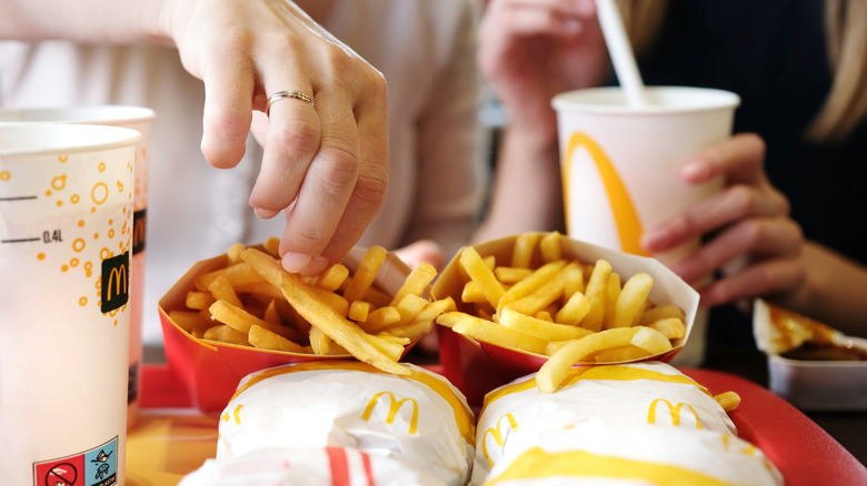 McDonald's meals on tray with fries and drinks in restaurant