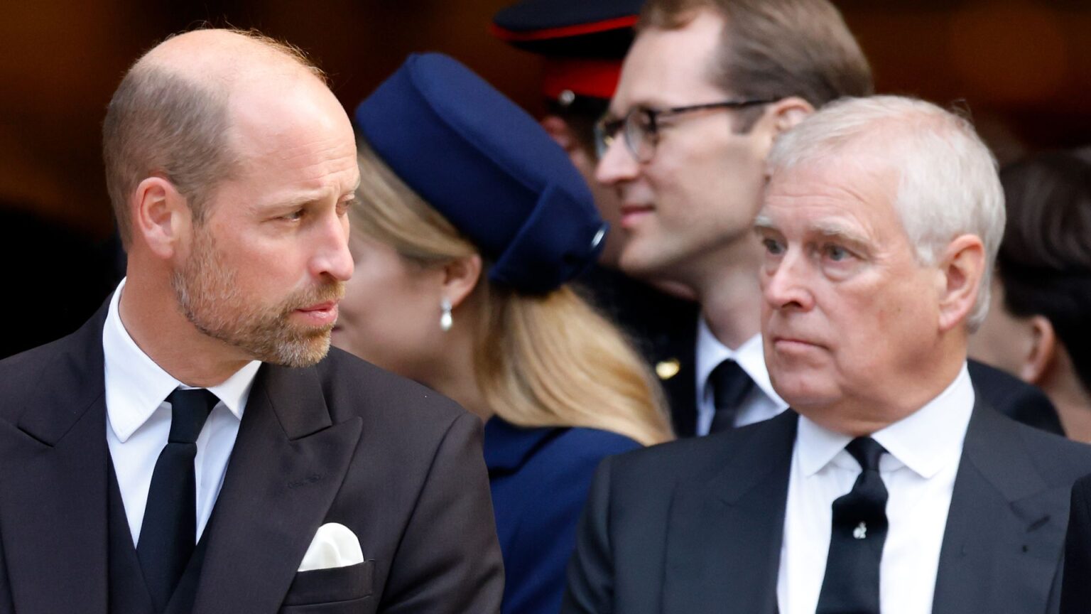 Prince William and ex-Prince Andrew both wear black suits with white shirts and black ties while attending a royal funeral at Westminster Cathedral