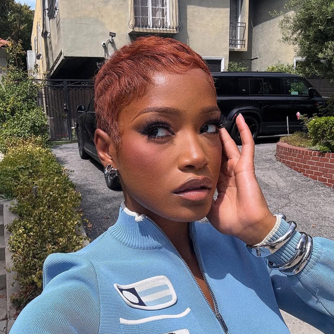 person taking a selfie outdoors with distinct clothing and accessories