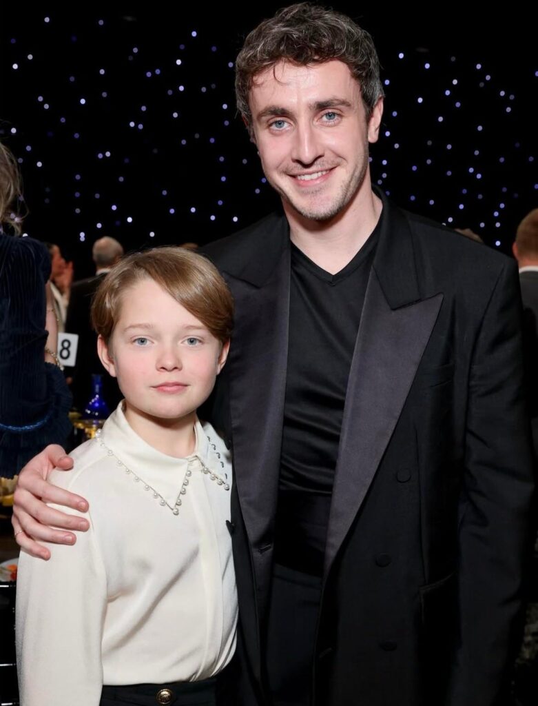 Nominee Jacobi Jupe (Hamnet) wears a Reiss faux-pearl trim satin shirt alongside costar Paul Mescal at the Critics Choice Awards