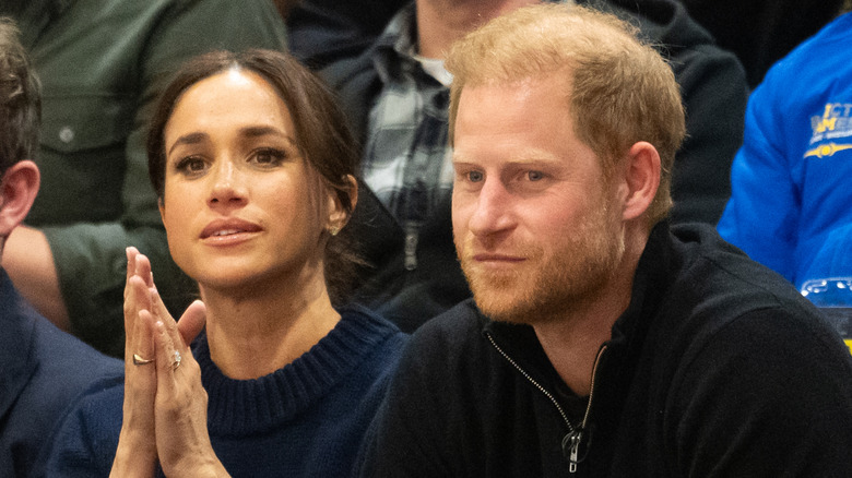 Meghan Markle and Prince Harry sitting in a crowd