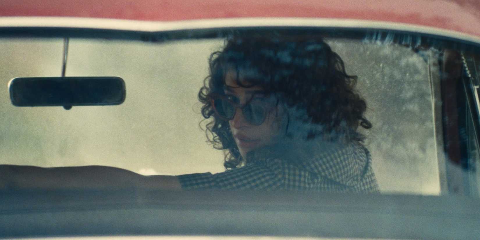 Odessa A'zion looking back in a car in Marty Supreme