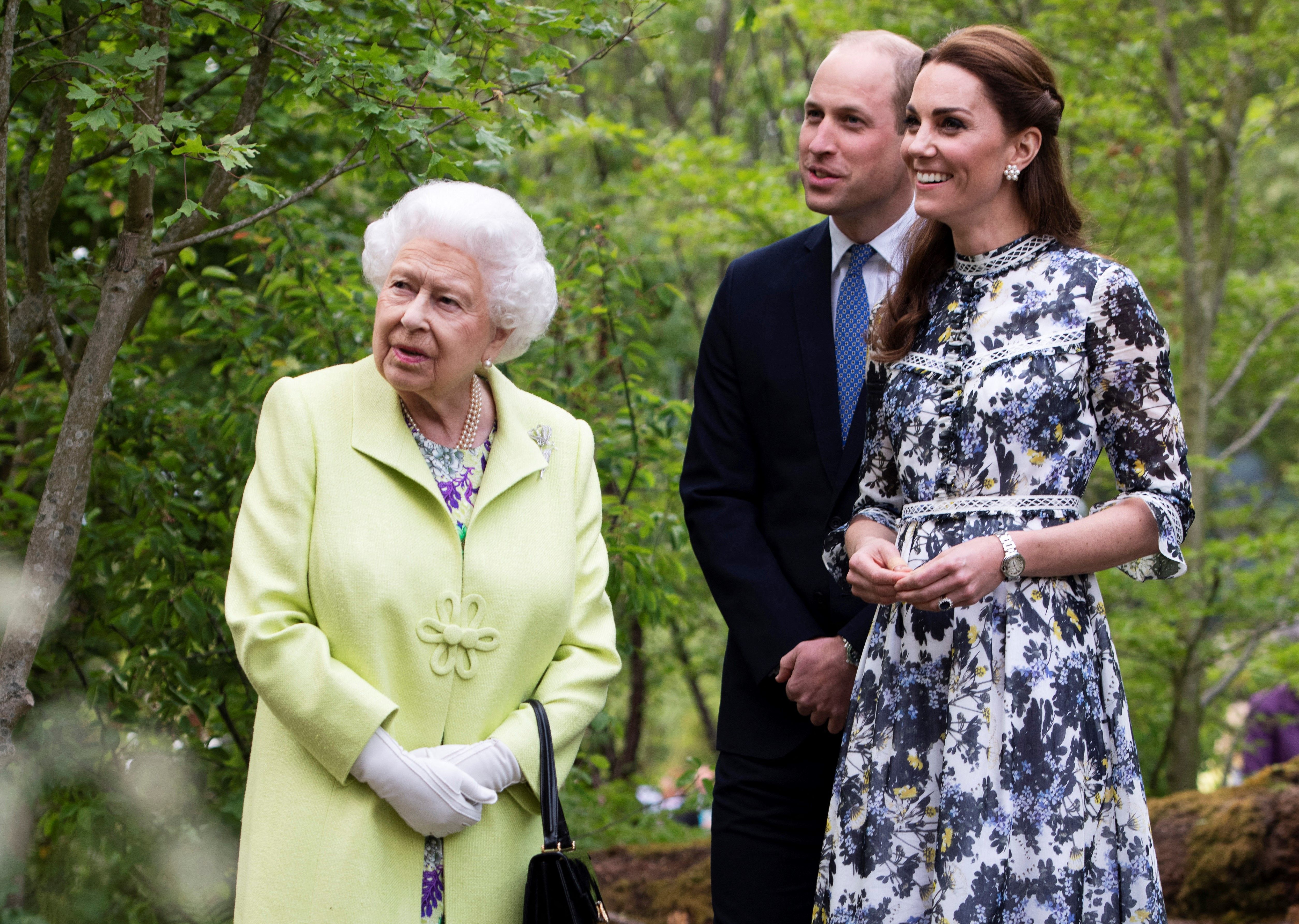 Queen Elizabeth, Prince William and Kate Middleton looking at a garden