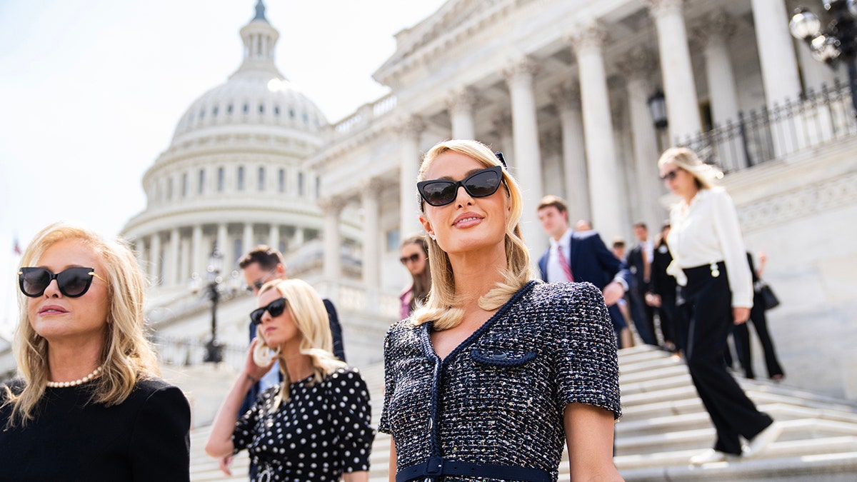 Paris Hilton walking alongside her mom and sister outside Capitol Hill.