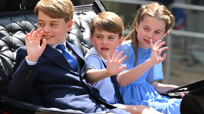 Prince George, Princess Charlotte, and Prince Louis wave from a carriage