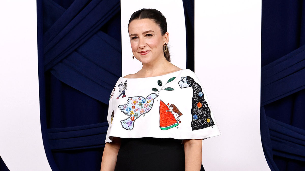 Rachel Griffin Accurso stands and poses for photographs at an awards event.