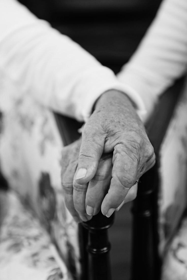 The Senna twins hold hands at their 100th birthday celebration.