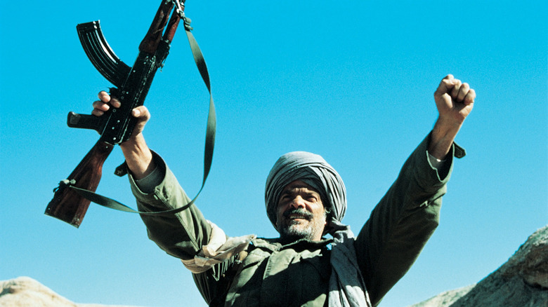 Masoud holds his hands up high in 