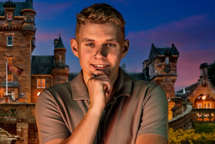 A man looking ahead with one hand resting on his chin.