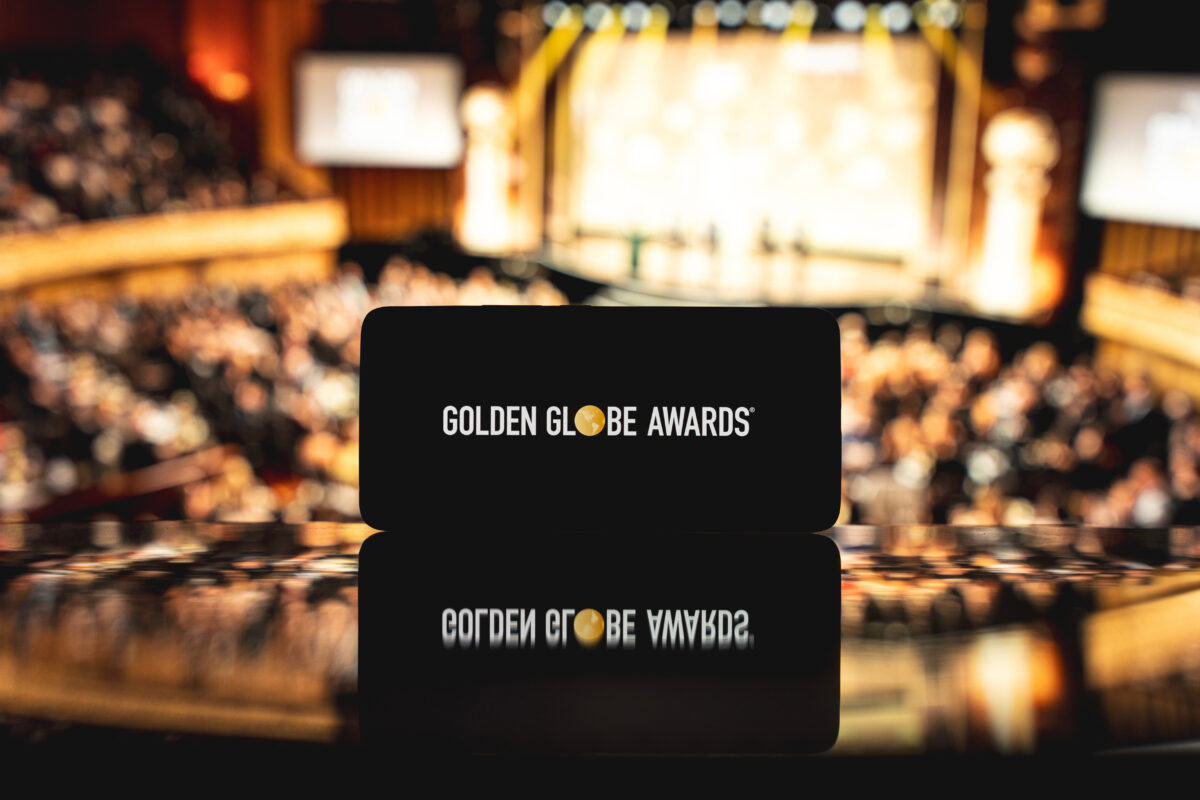 Photo shows a phone with "Golden Globe Awards" on the screen against a backdrop of a stage and crowd