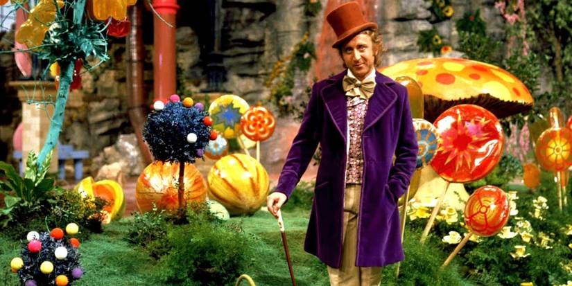 Willy Wonka (Gene Wilder) stands in front of assorted candies in Willy Wonka and the Chocolate Factory.